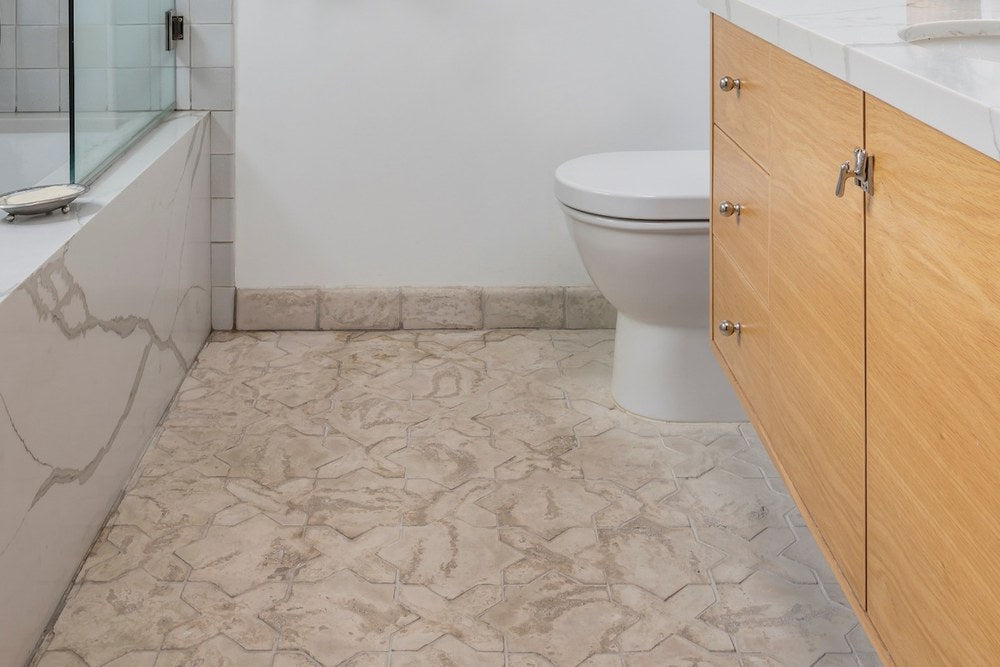 Artillo surface bullnose run as a base against a wall, over an Arabesque 2C floor, Early Gray color, Limestone texture