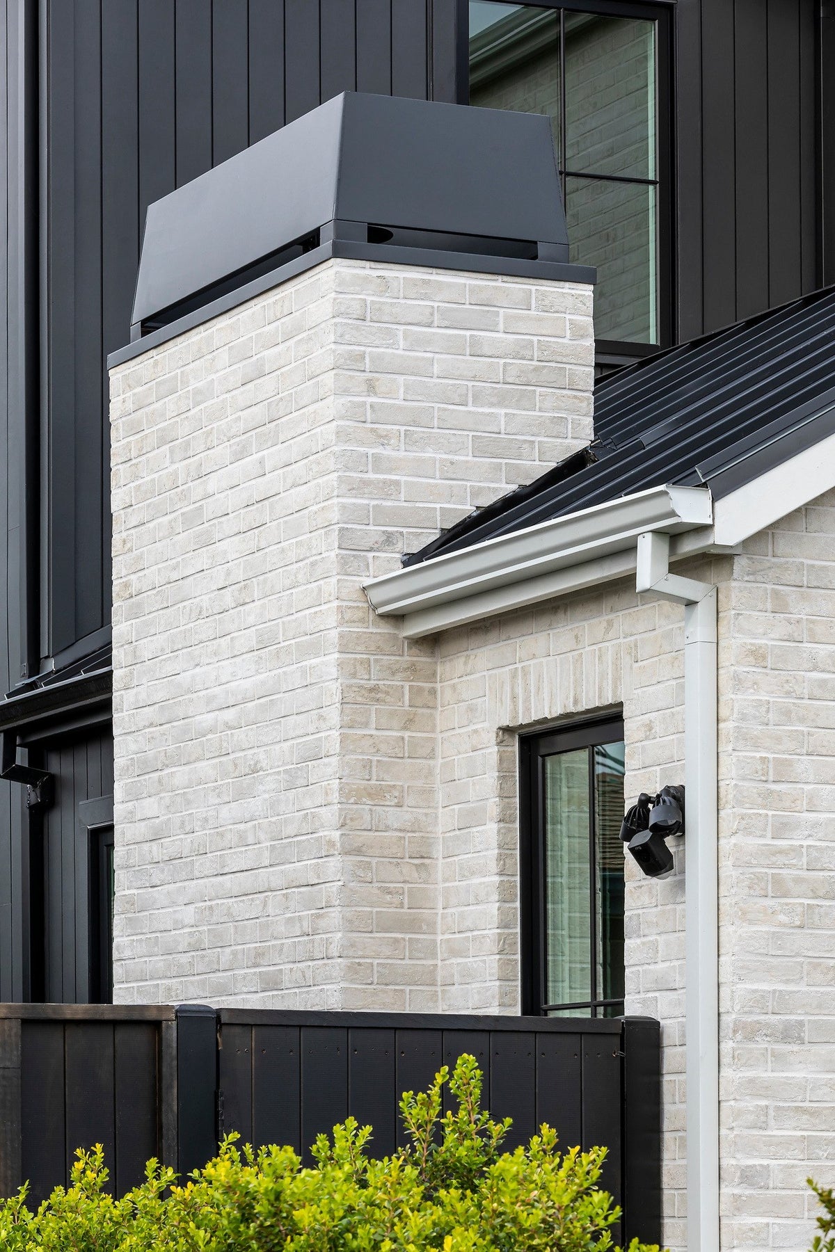 Brick chimney against dark siding