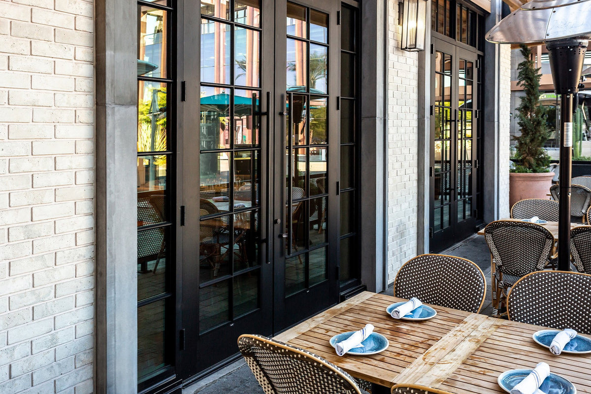 Patio tables beside steel-framed doors