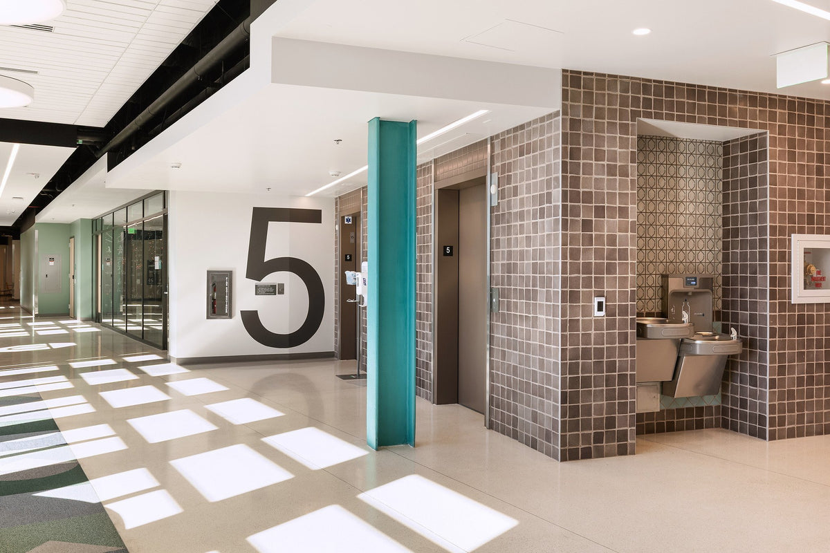 Tiled elevator core in the sunlit lobby