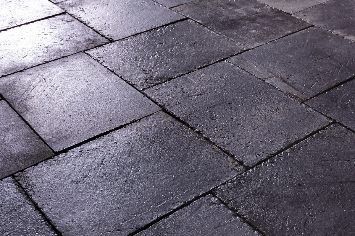 Kuro laid as a floor, black grey tile catching low light across its glazed surface