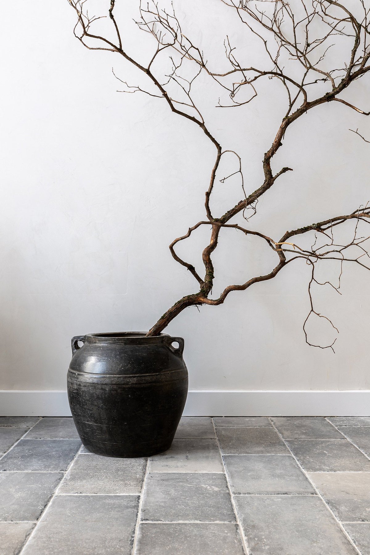 Pottery and branches on gray tile