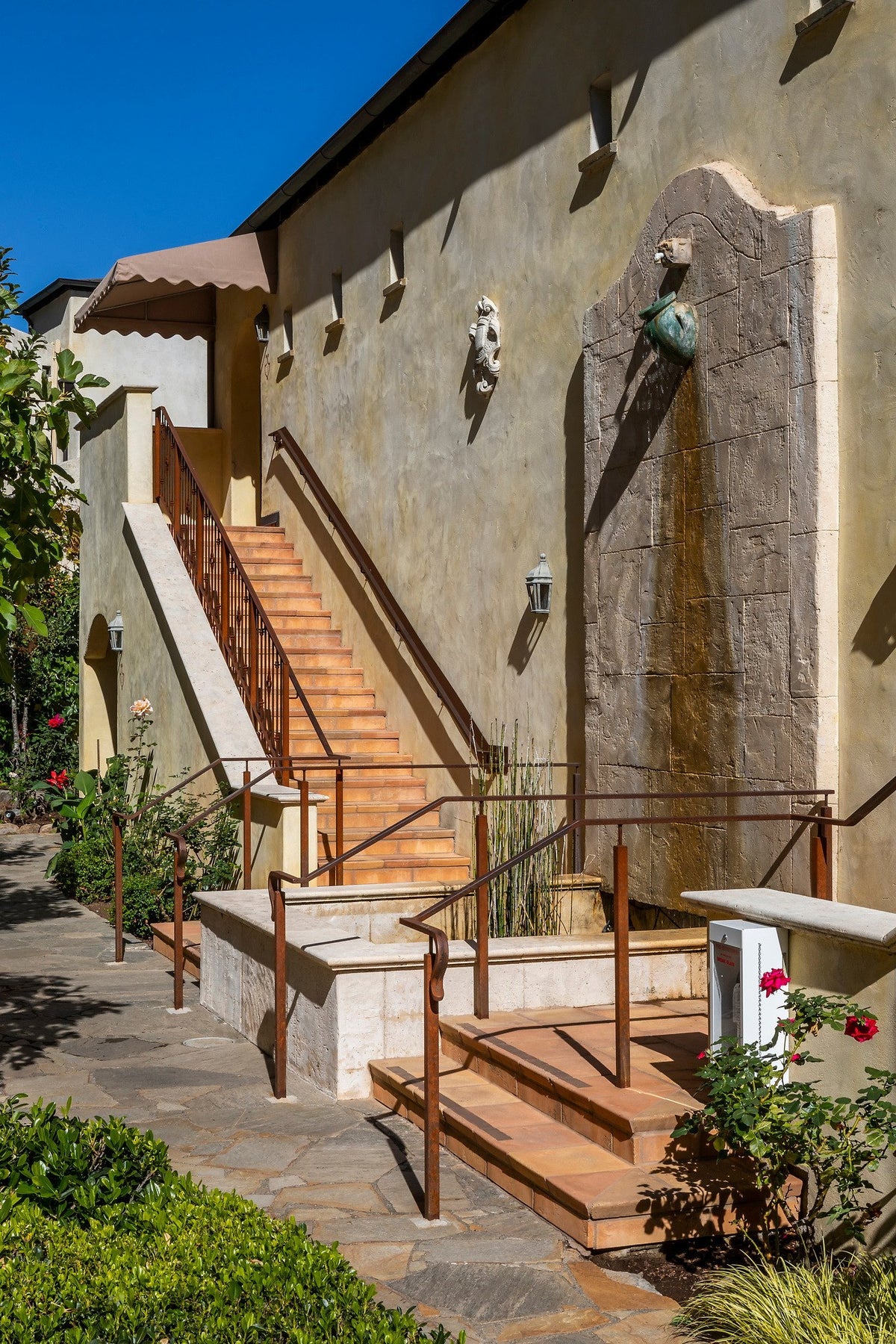 Exterior stairs beside a wall fountain