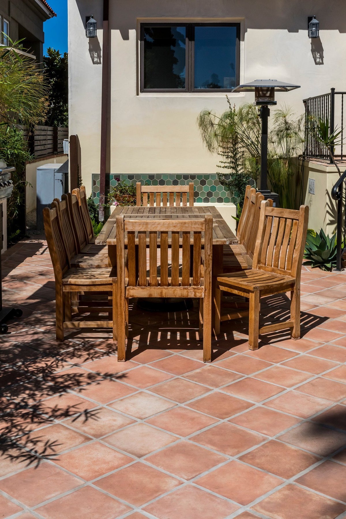 Teak dining set on the tiled patio