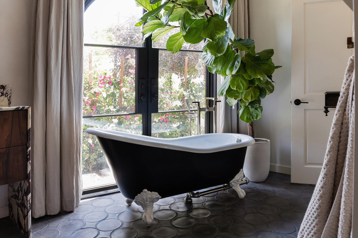 Clawfoot tub by arched windows