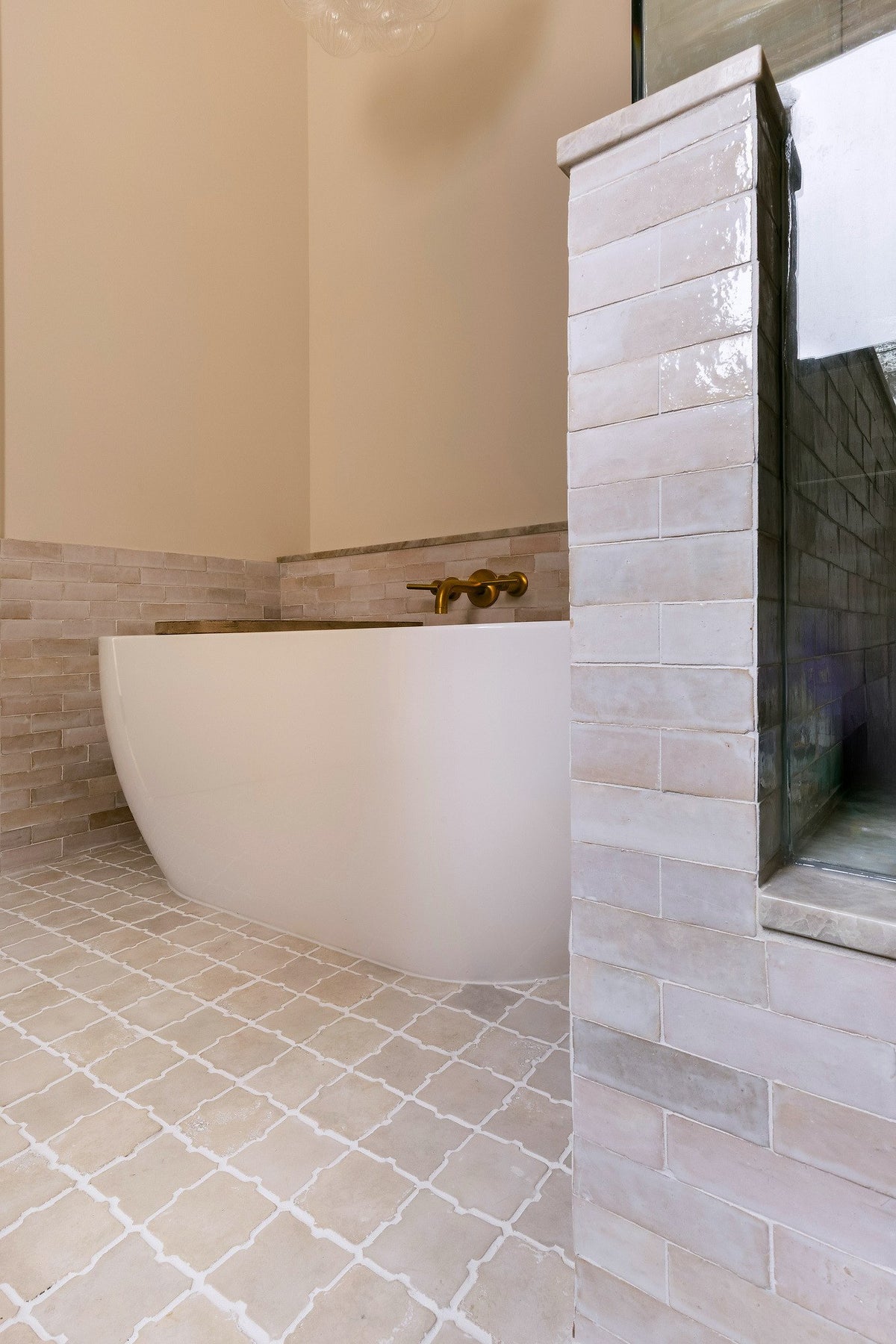Tub beside the tiled shower wall
